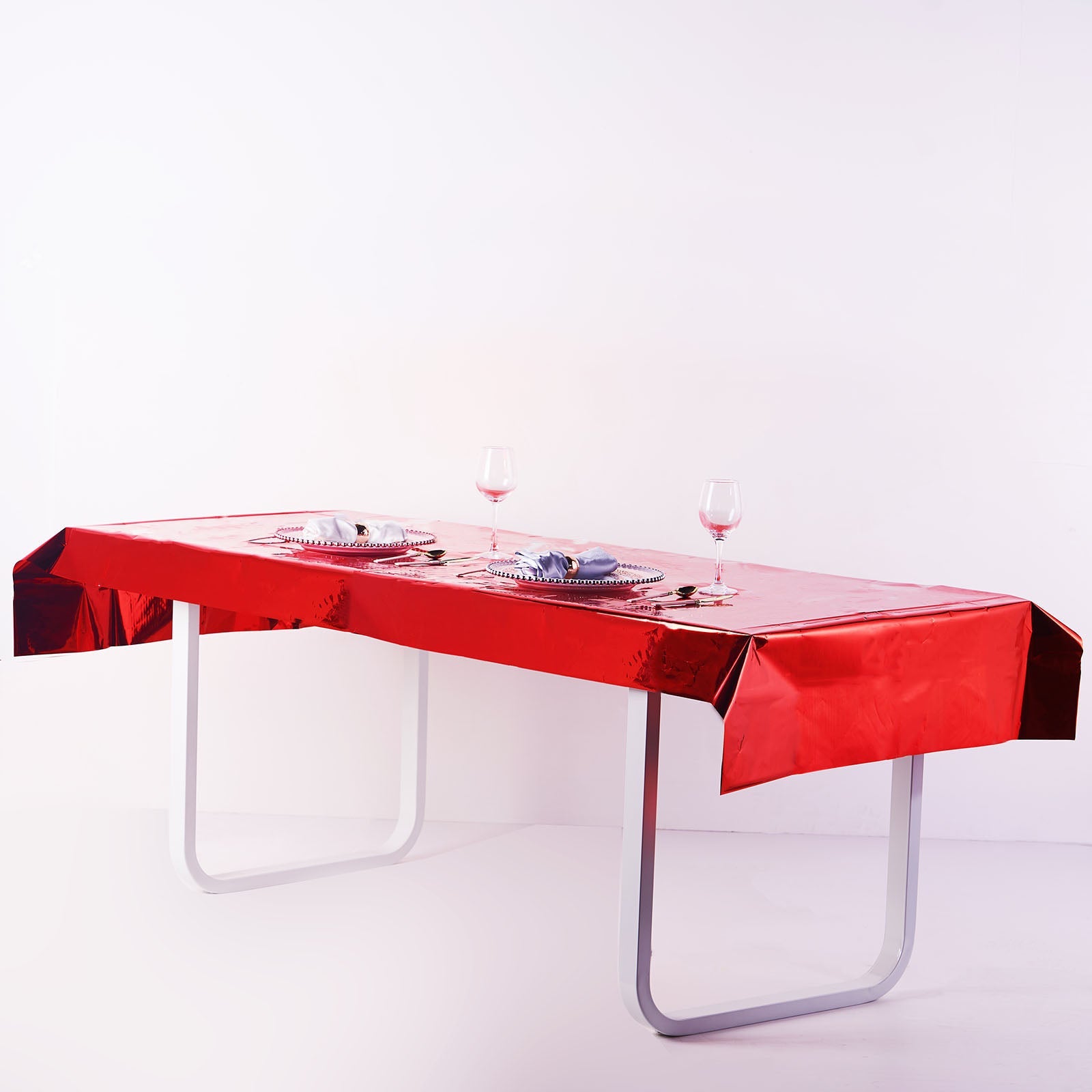 Red metallic foil disposable tablecloth on a rectangular table.