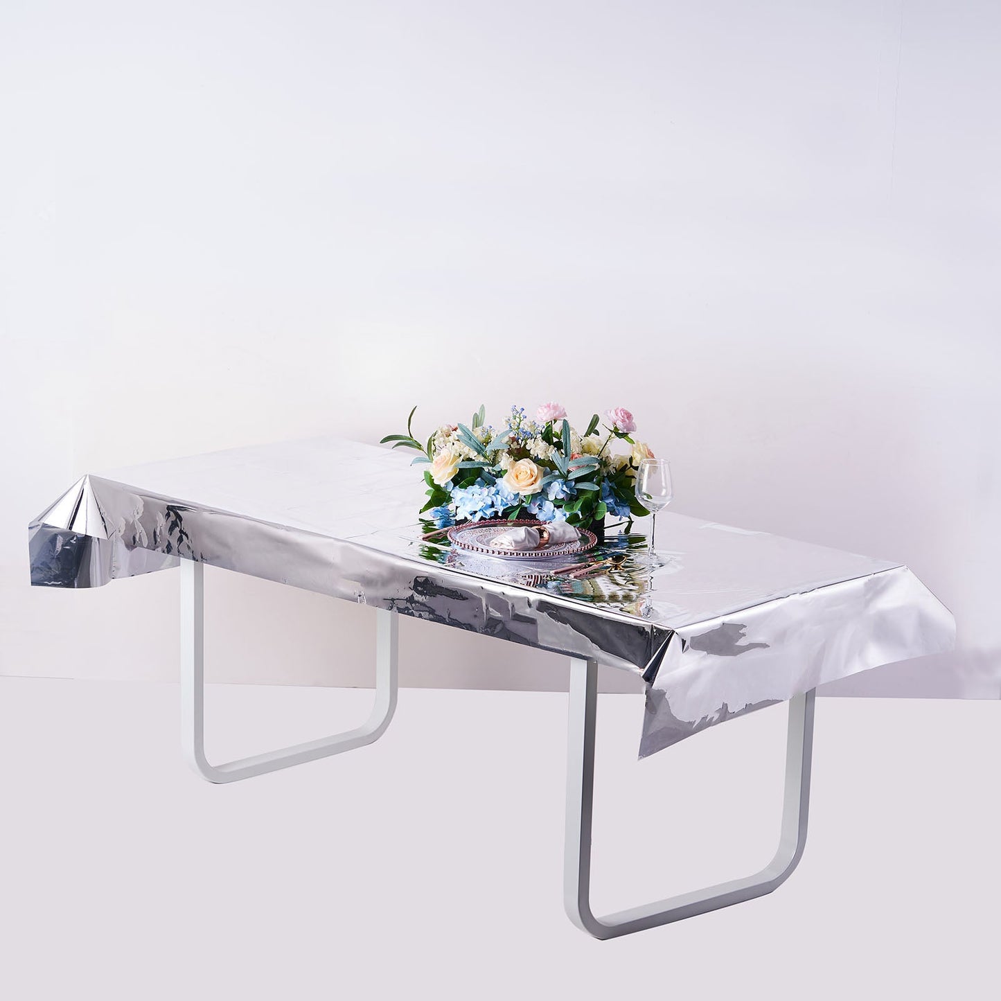 Silver metallic foil rectangle tablecloth on a dining table.