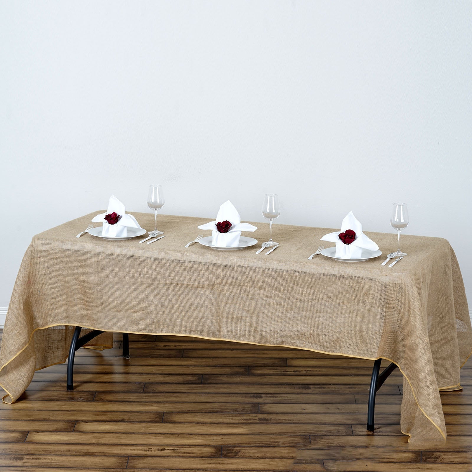 Natural rustic burlap tablecloth on a wooden table with elegant place settings.