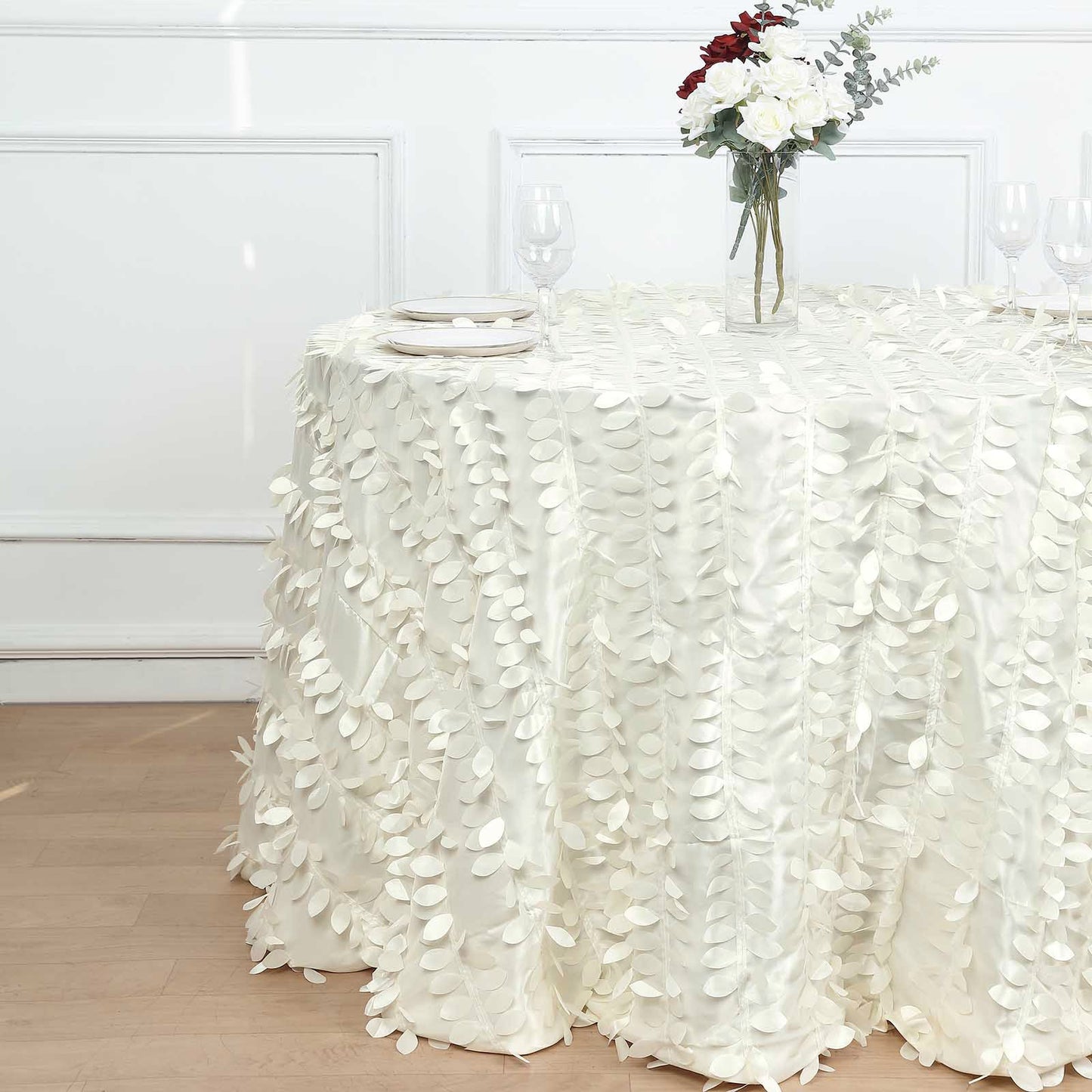 Ivory leaf petal taffeta seamless round tablecloth on a table.