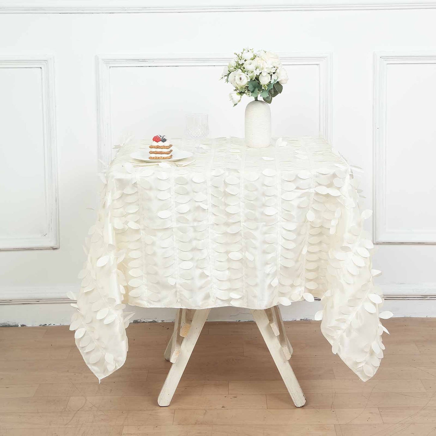 Ivory 3D leaf petal taffeta fabric square overlay on a table.