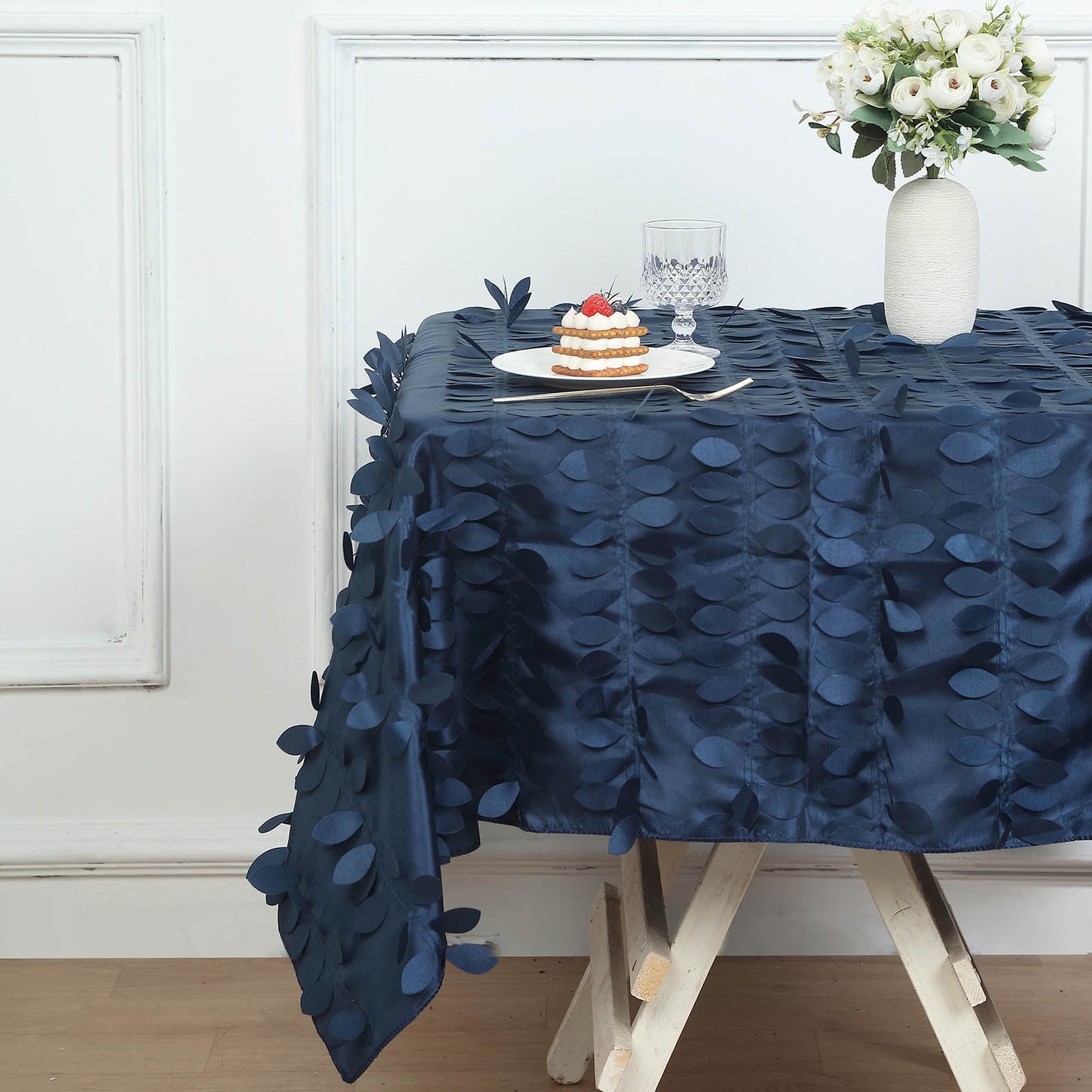 Navy blue 3D leaf petal taffeta fabric square tablecloth on a table.
