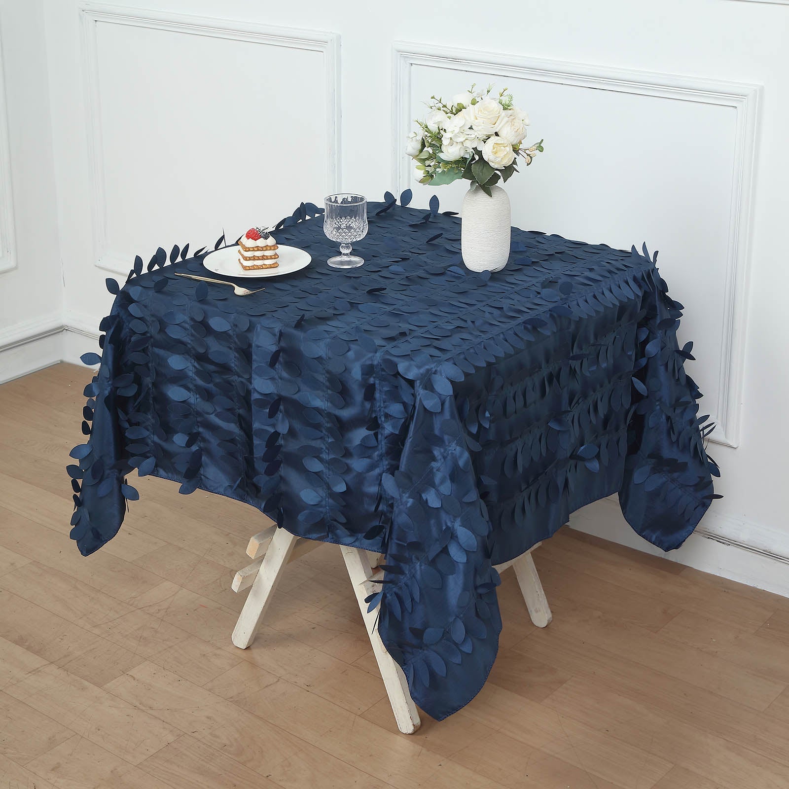 Navy blue 3D leaf petal taffeta fabric square tablecloth on a table.