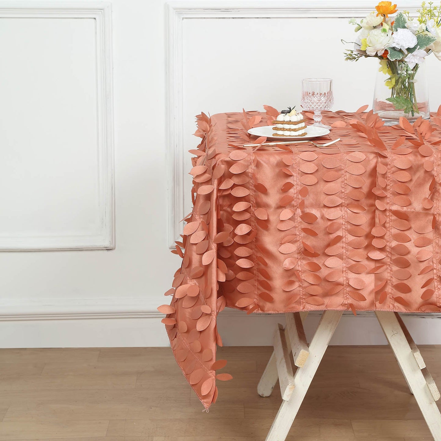 Terracotta 3D leaf petal taffeta table overlay on a wooden table.