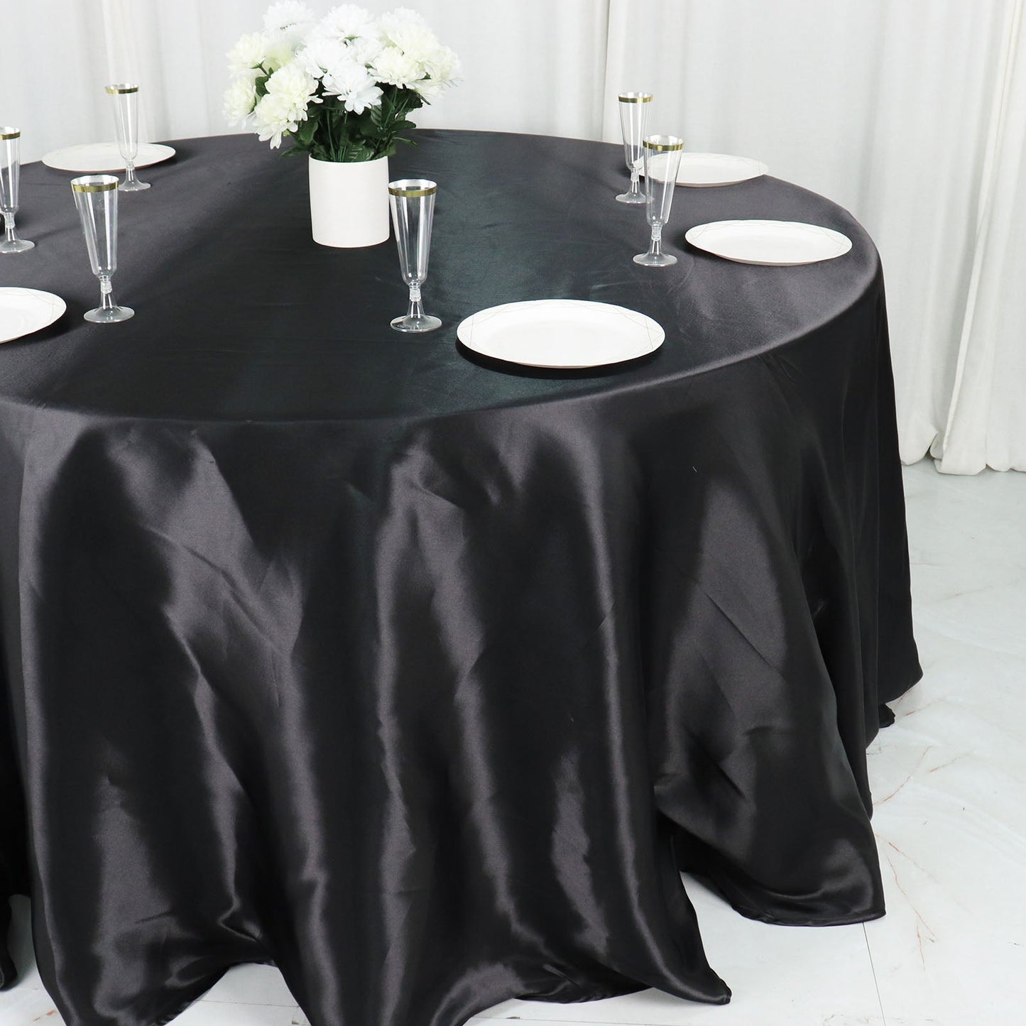 Black seamless satin round tablecloth on a dining table.