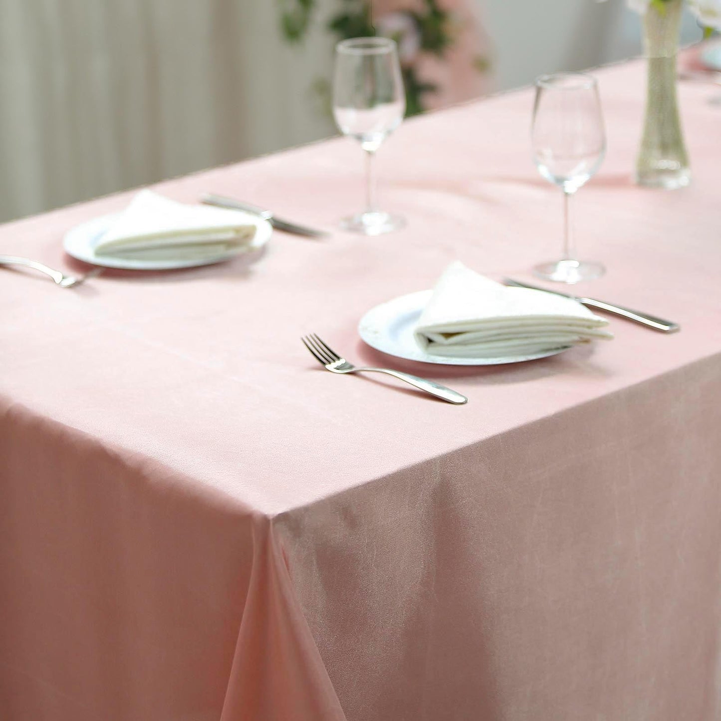 Dusty rose satin rectangular tablecloth on a dining table.
