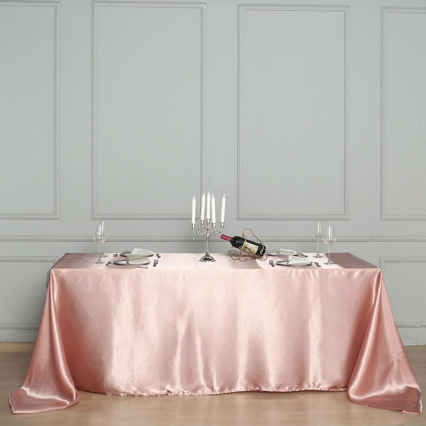 Dusty rose satin rectangular tablecloth on a dining table.