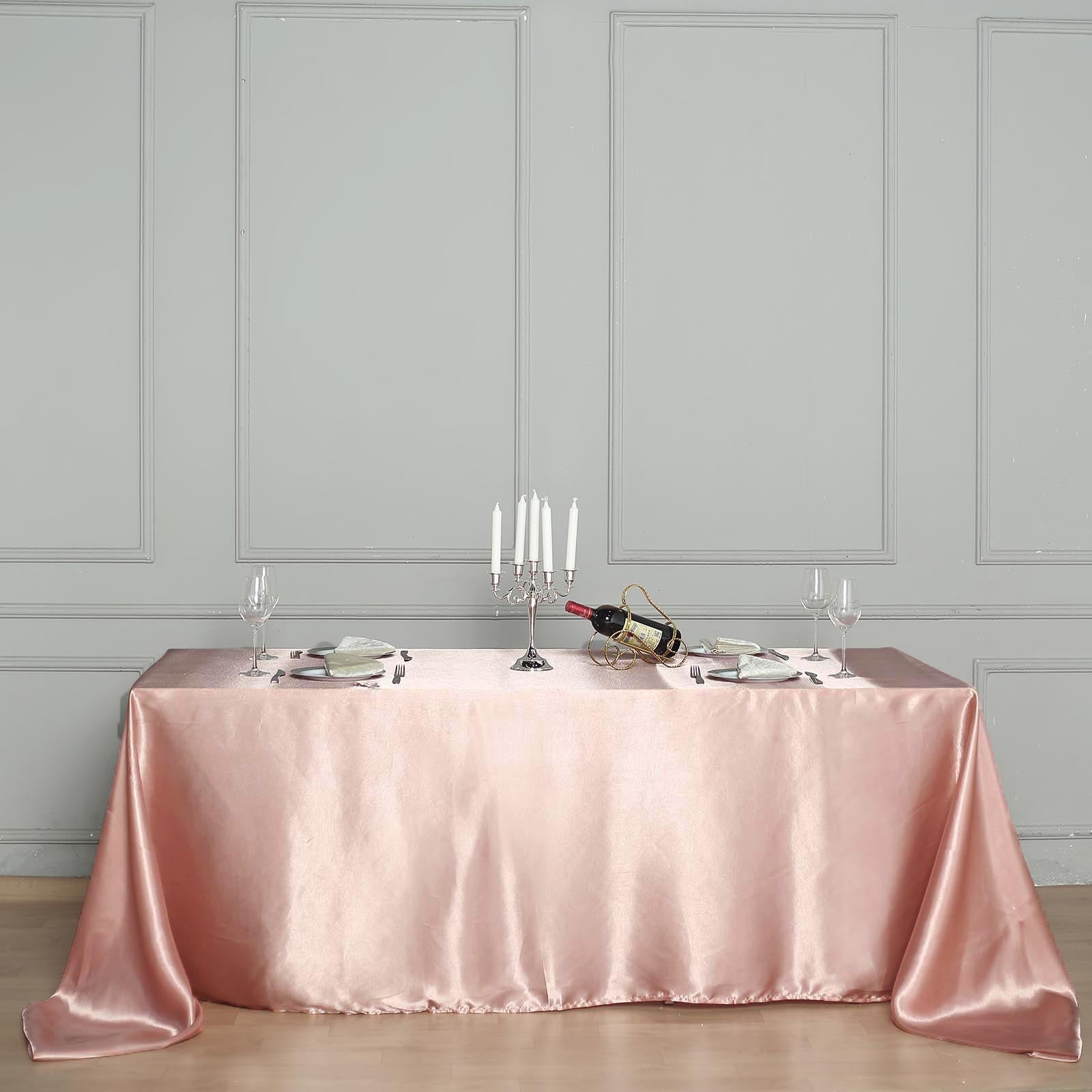 Dusty rose satin rectangular tablecloth on a dining table.
