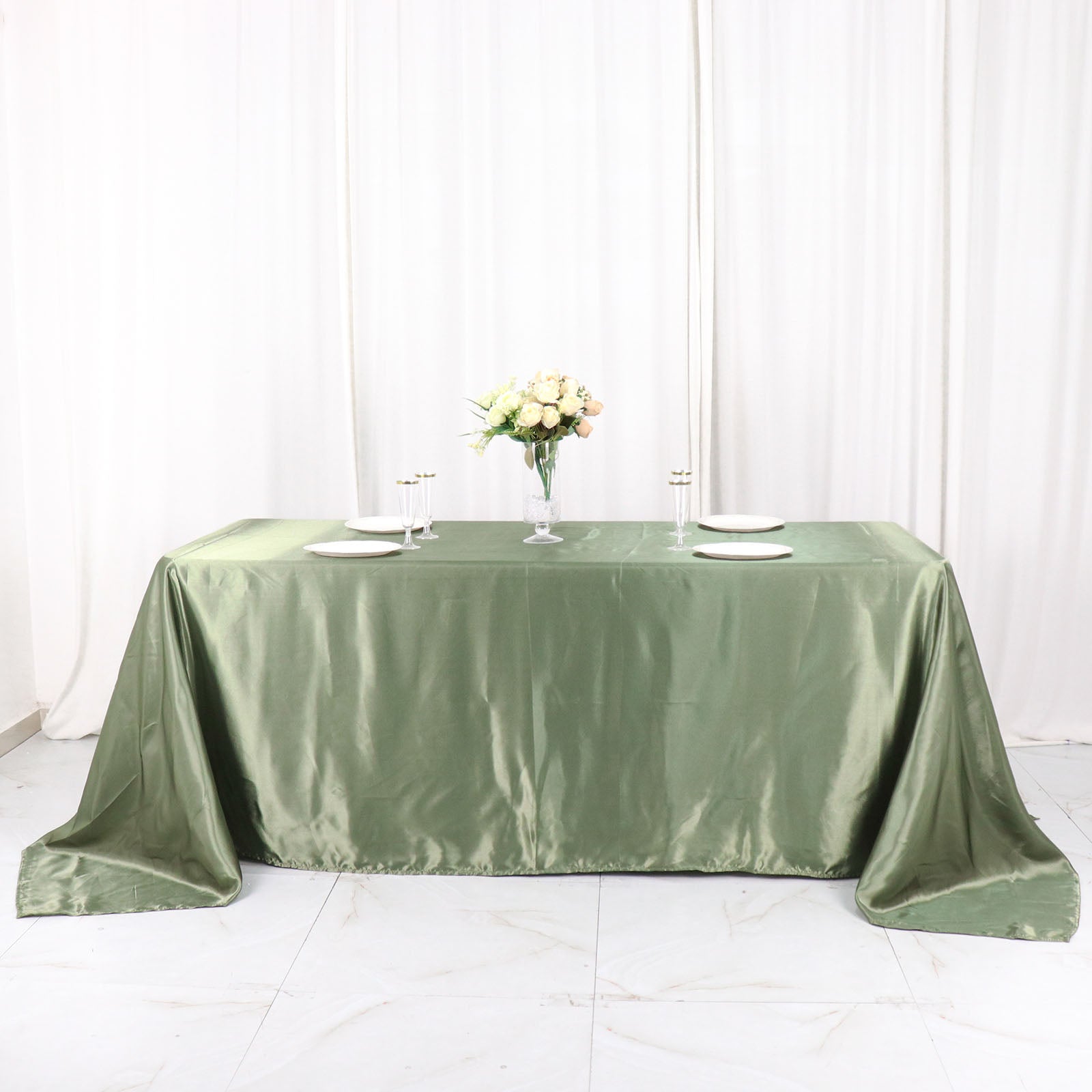 Dusty sage green satin rectangular tablecloth on a dining table.