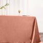 Terracotta satin rectangular tablecloth on a dining table.