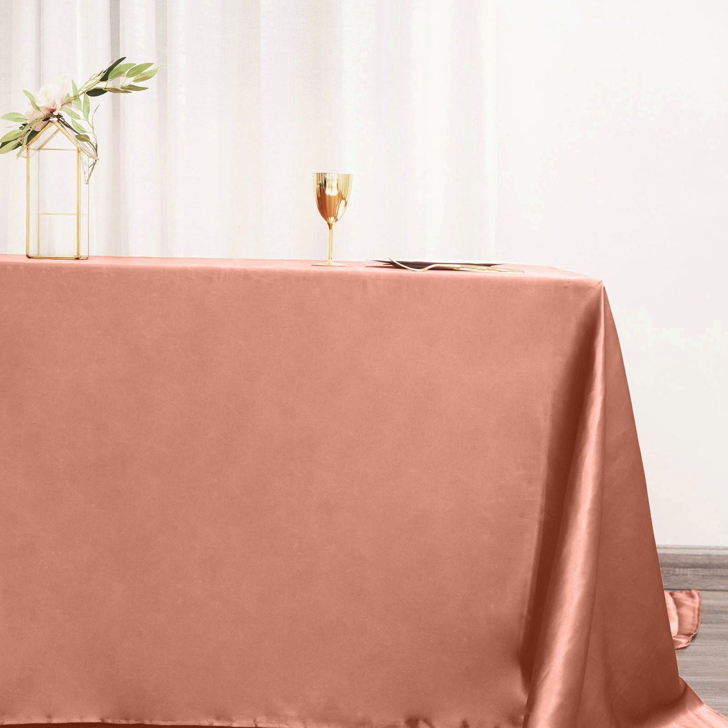 Terracotta satin rectangular tablecloth on a dining table.