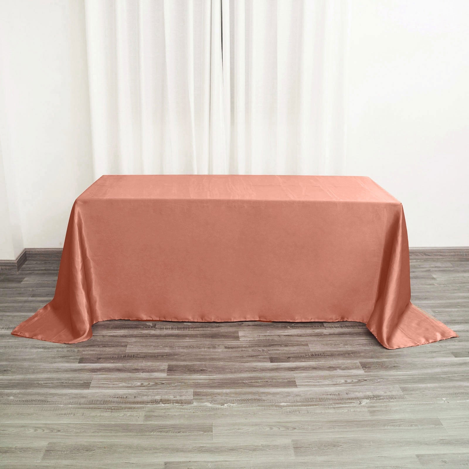 Terracotta satin rectangular tablecloth on a wooden floor.