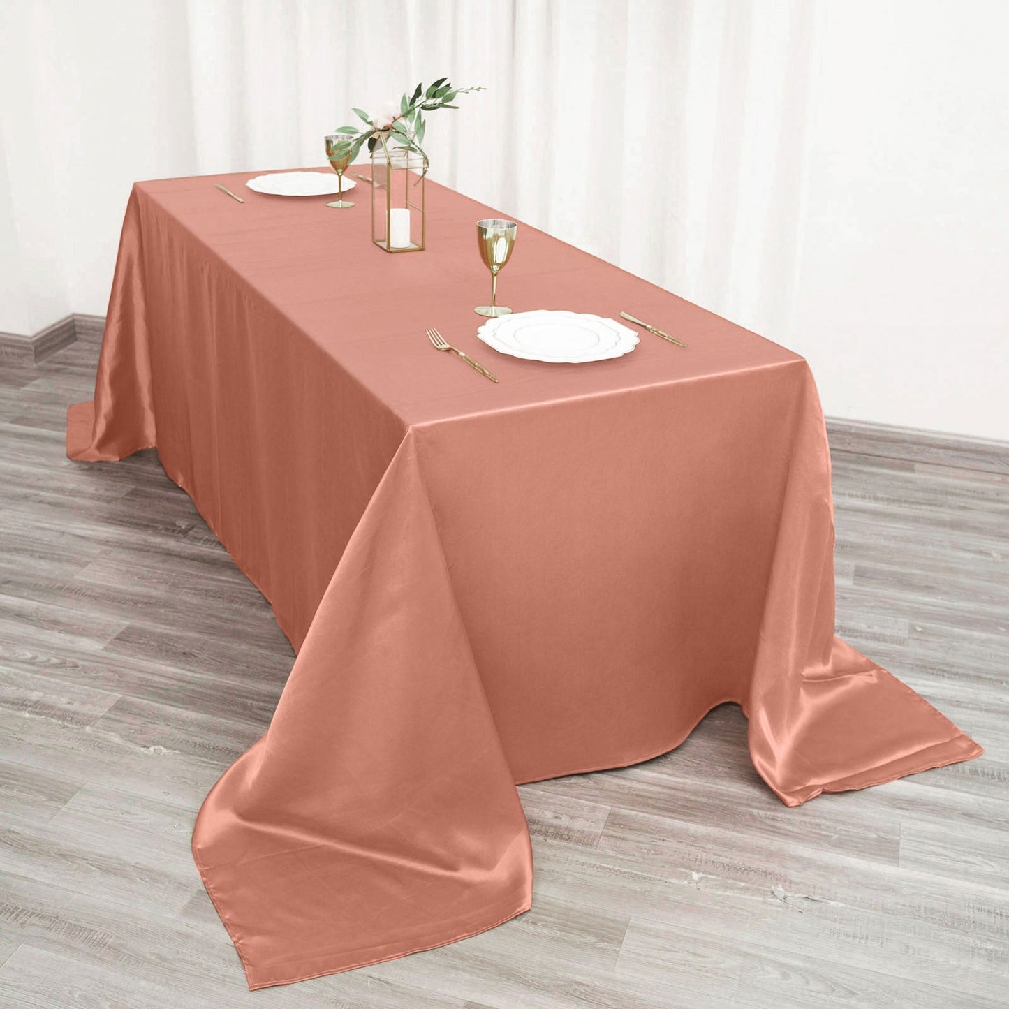 Terracotta satin rectangular tablecloth on a wooden table setting.
