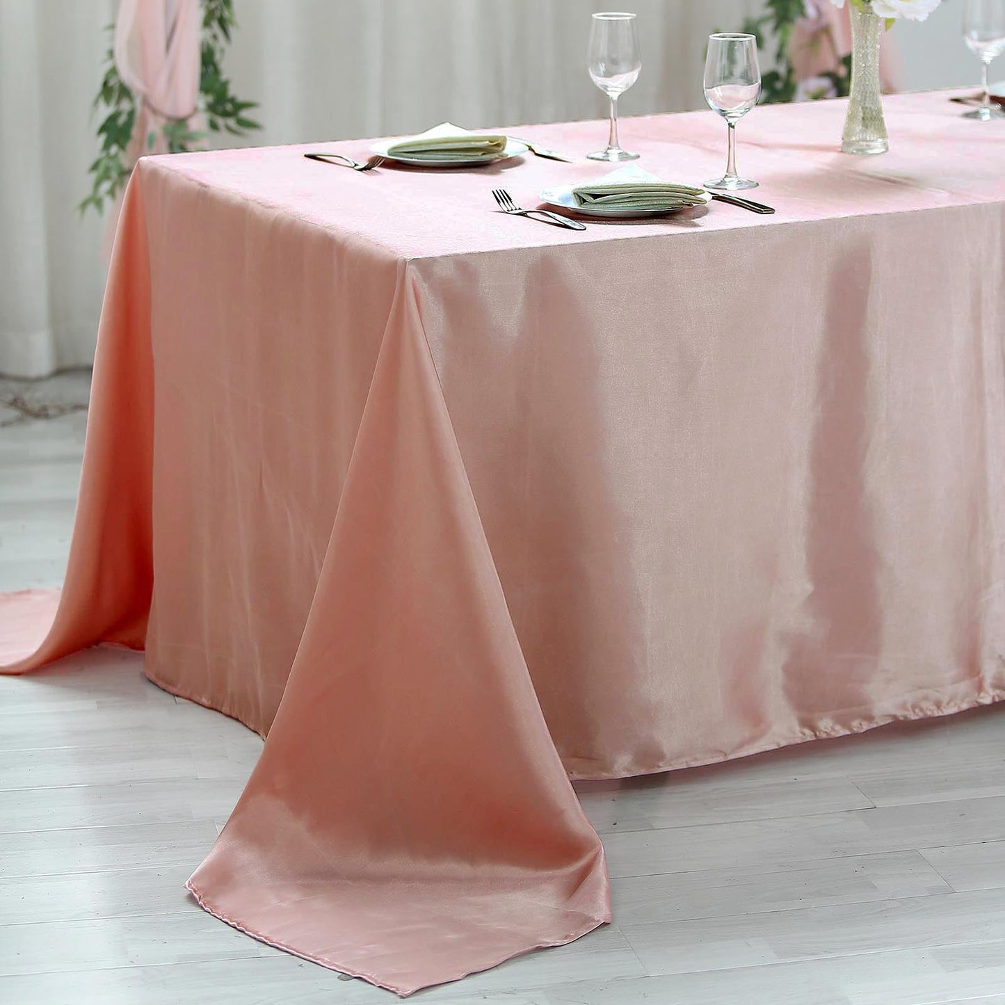 Dusty rose satin rectangular tablecloth on a dining table.