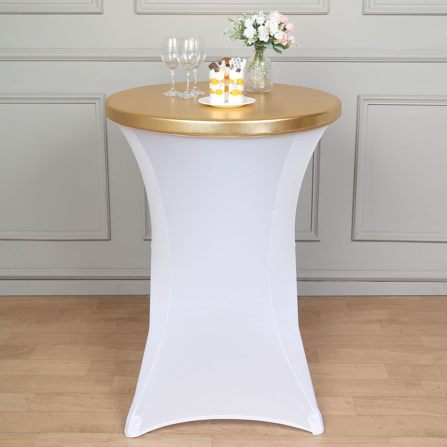 Metallic gold spandex stretch fitted cocktail table top cover on a white table.