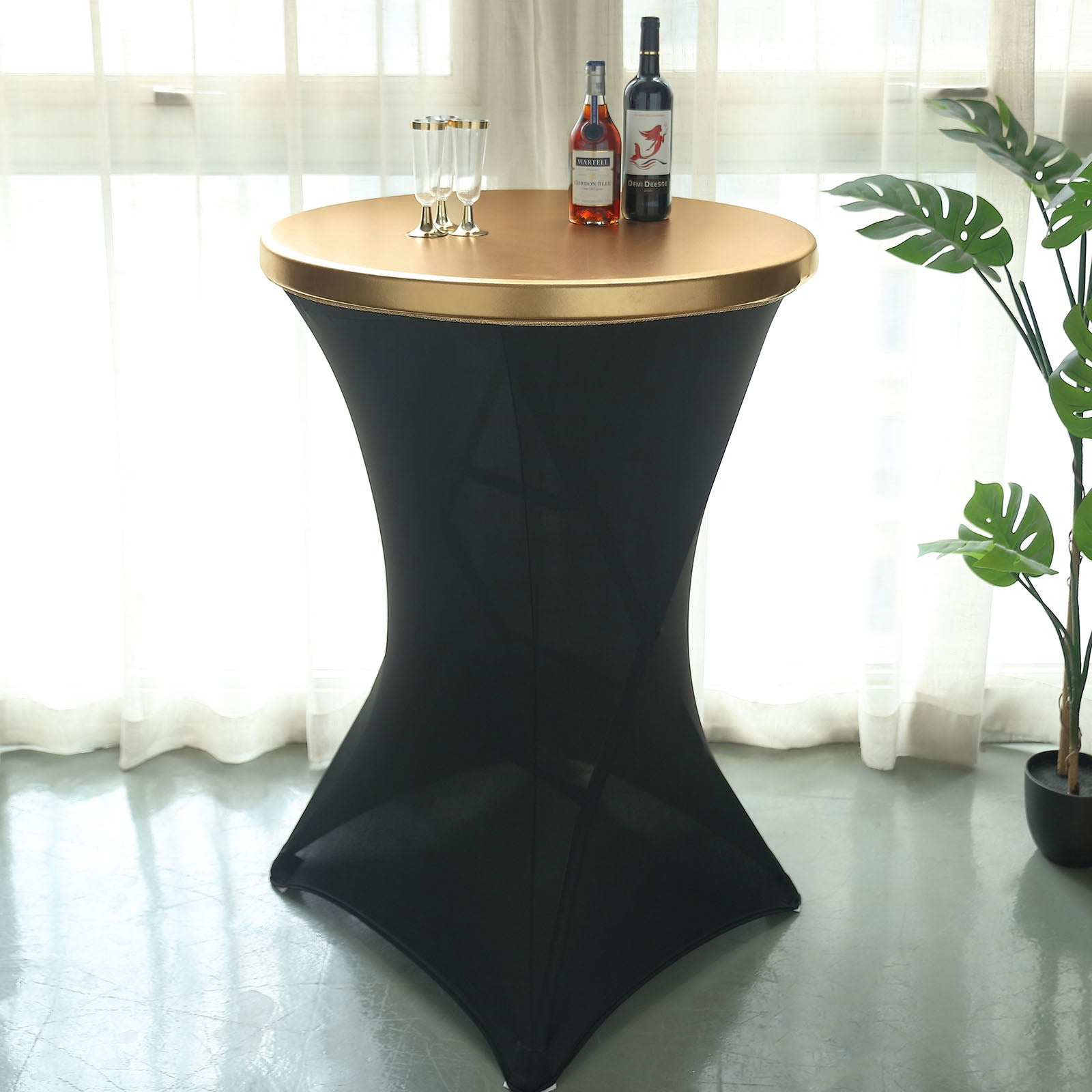 Metallic gold fitted cocktail table cover on a black table.