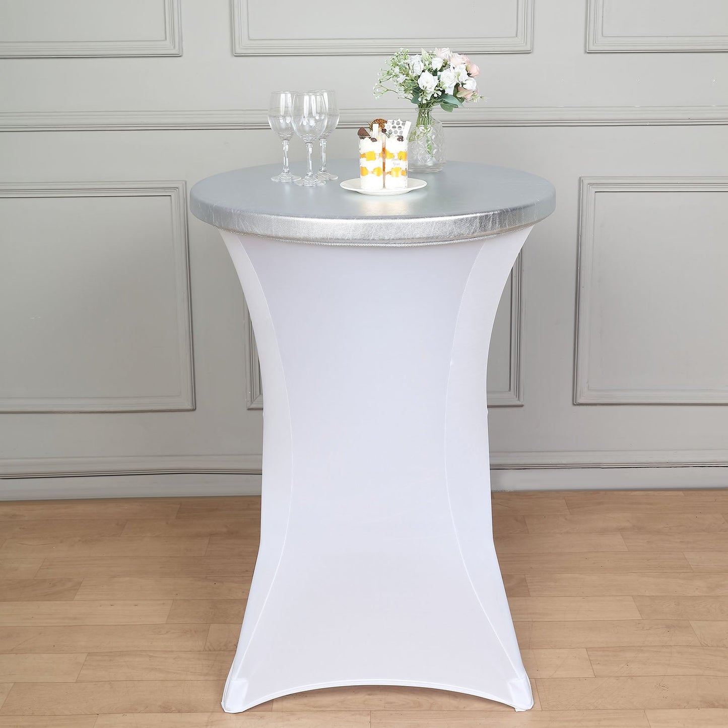 Metallic silver spandex stretch fitted cocktail table cover on a round table.