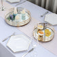 Gold round mirror serving trays on a table with desserts and flowers.