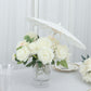 White parasol umbrella in a floral centerpiece for wedding decor.