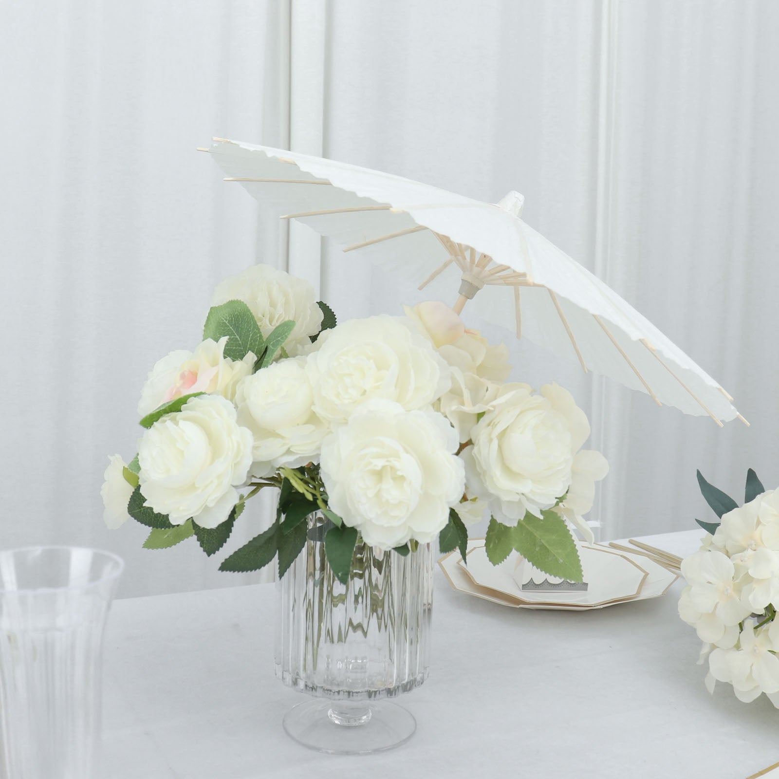 White parasol umbrella in a floral centerpiece for wedding decor.