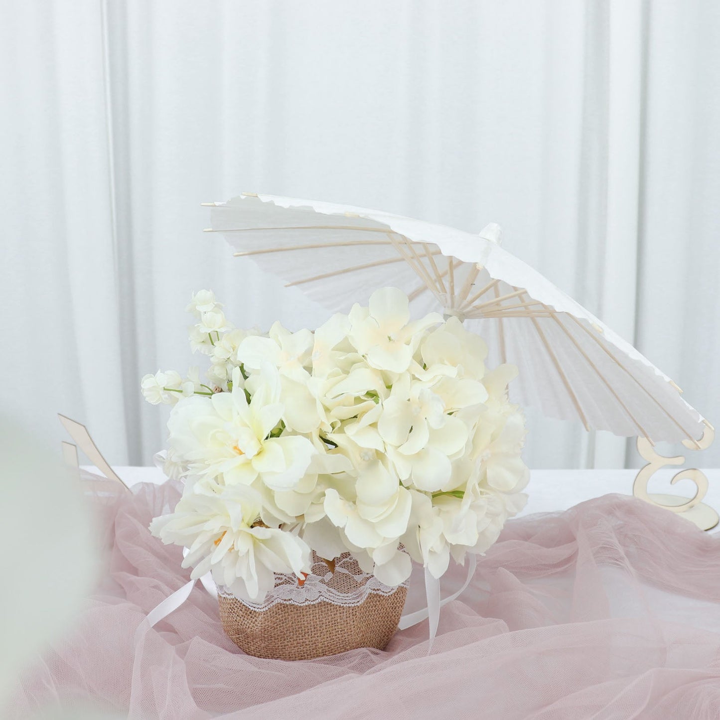 White parasol umbrella with floral centerpiece in a decorative arrangement.