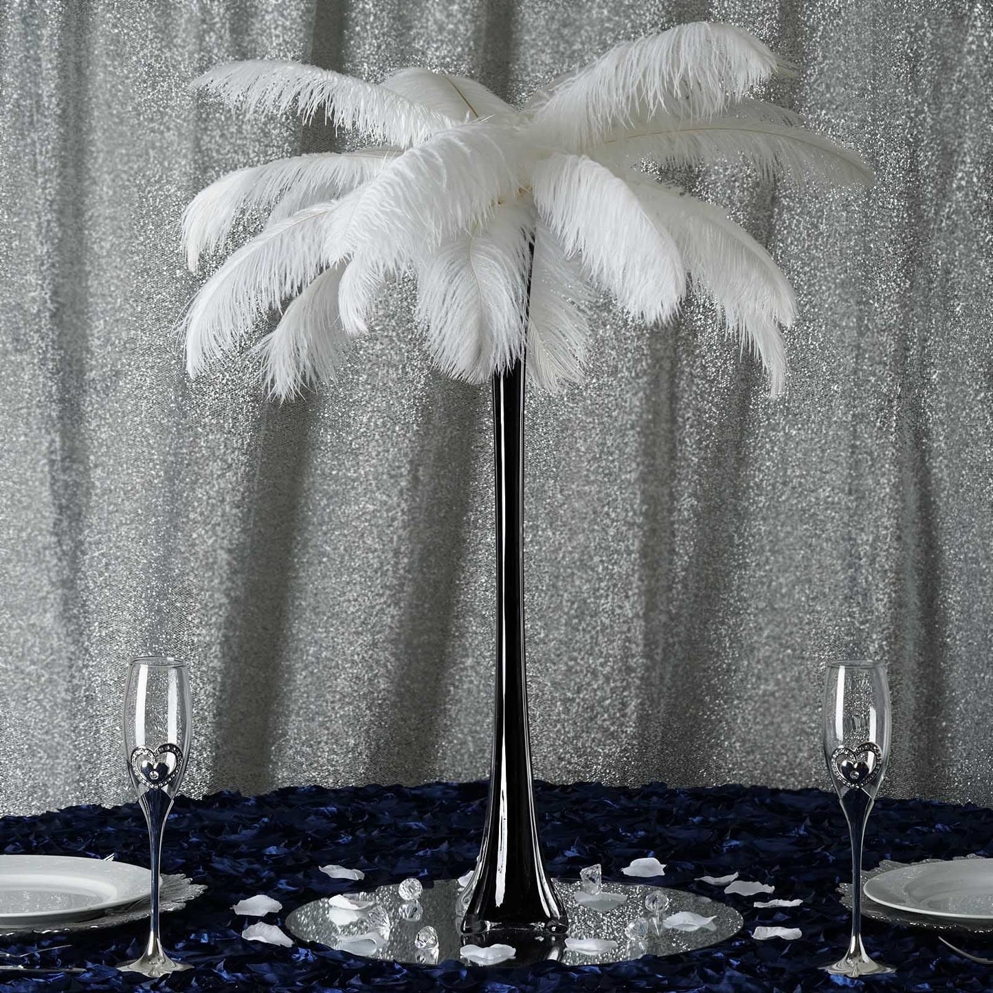 Black Eiffel Tower glass flower vase with white feathers and elegant table setting.