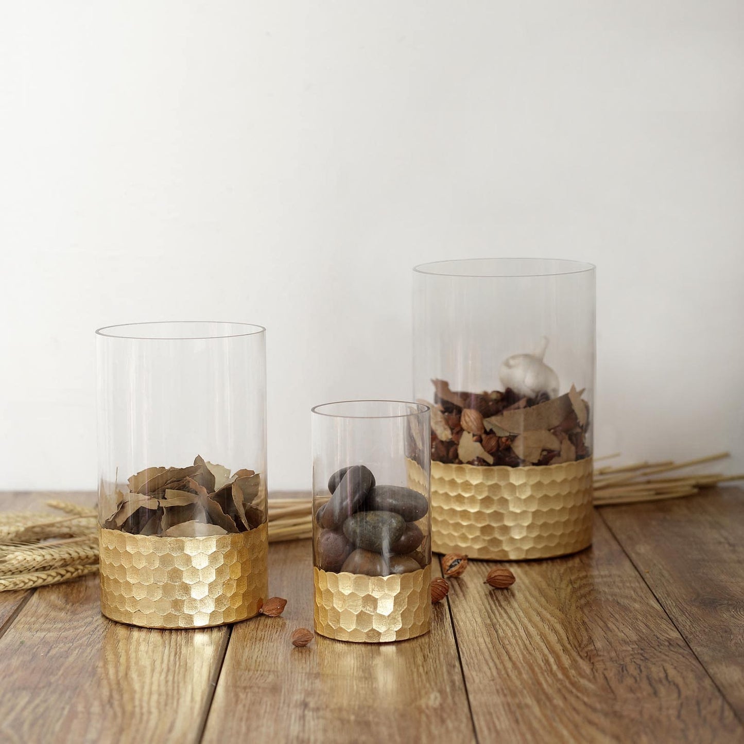 Set of 3 clear glass vases with gold honeycomb bases, 6", 8", and 10" tall.