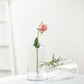Clear glass flower bud vases with pink rose centerpiece.