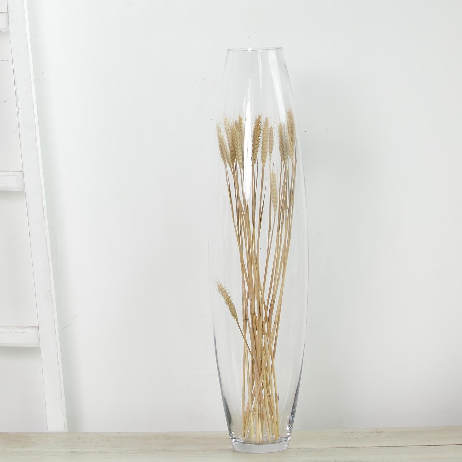 Clear vase with dried wheat stems, perfect for home decor.