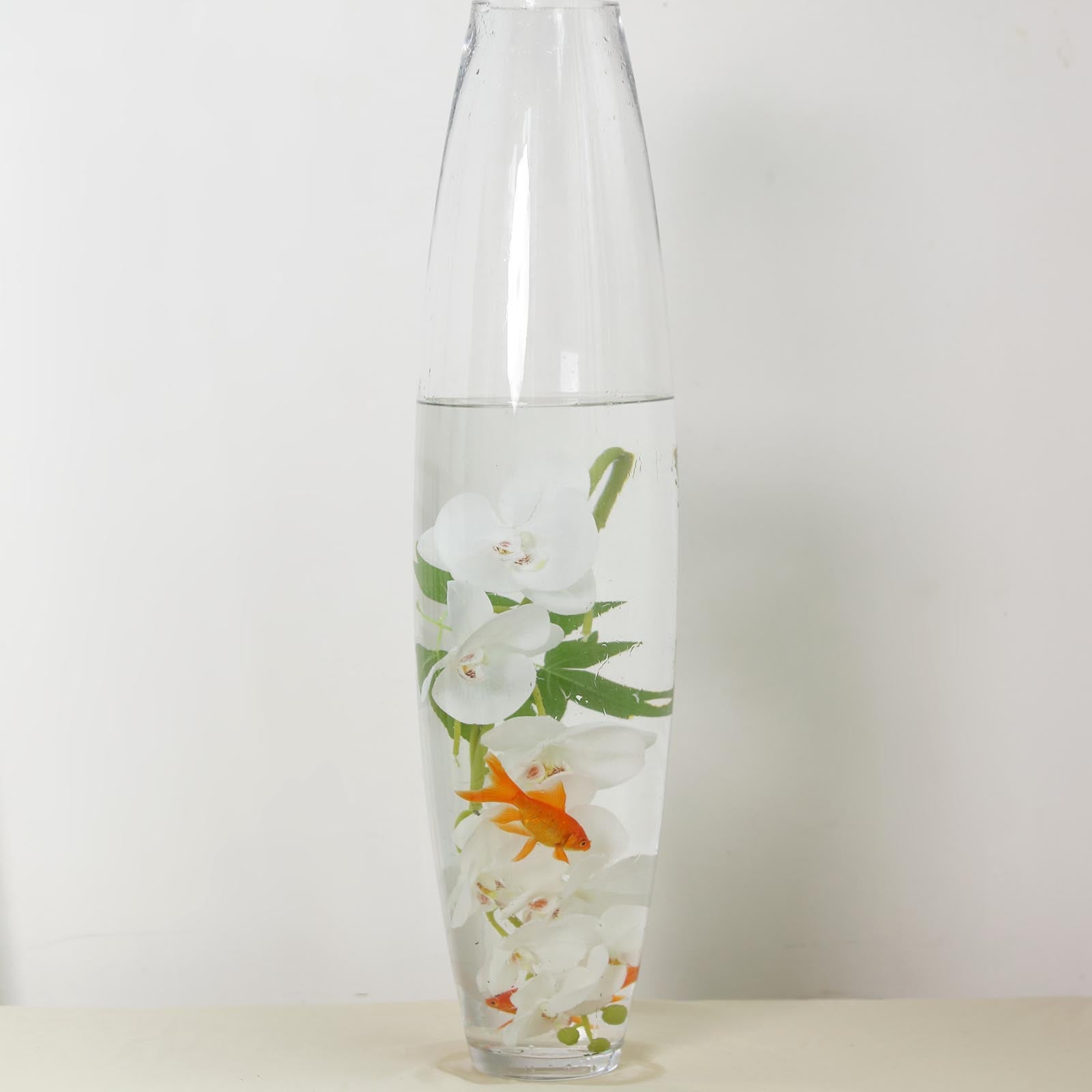 Elegant vase with water, white flowers, and a goldfish for a serene decor.