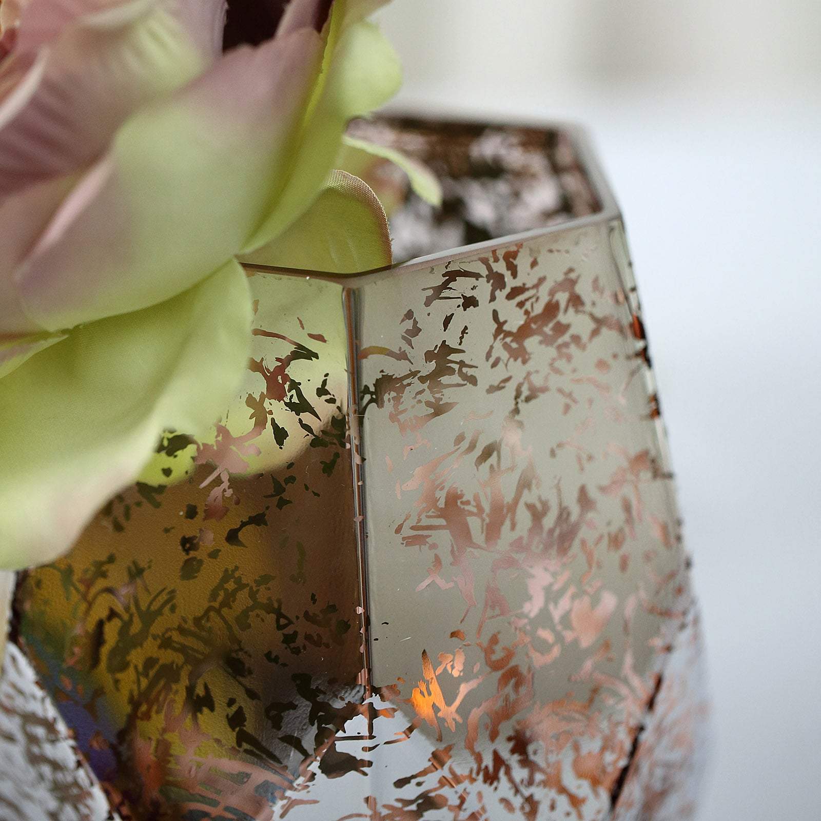 Rose gold pentagon vase with floral arrangement.
