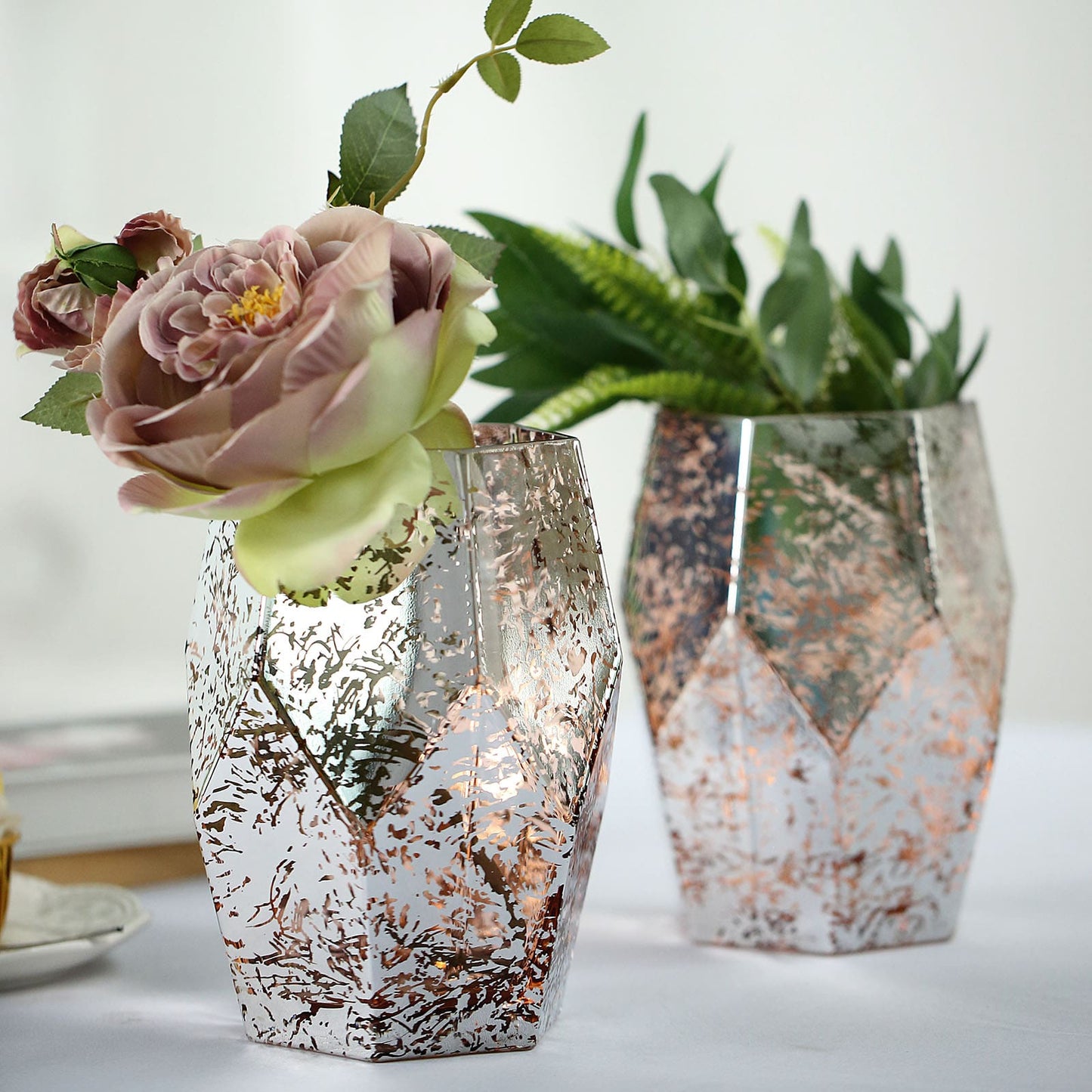 Silver and rose gold geometric vases with flowers.