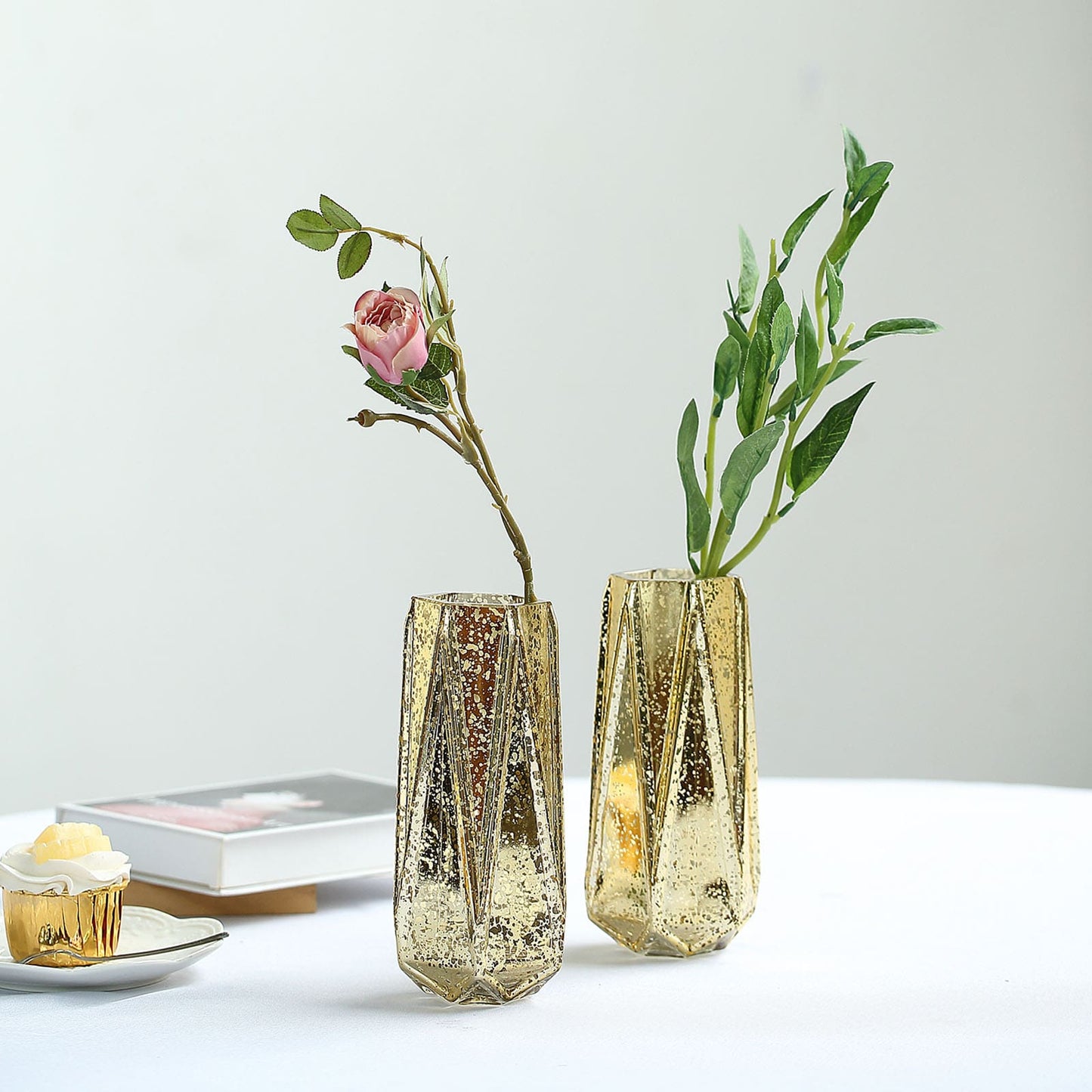 Gold geometric vases with flowers, perfect for centerpieces.