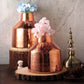Rose gold mercury glass vases with flowers, perfect for centerpieces.