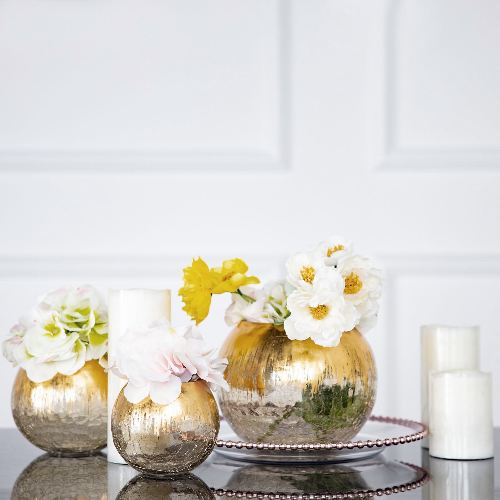 Gold foiled crackle glass bud vase with flowers, elegant table centerpiece.