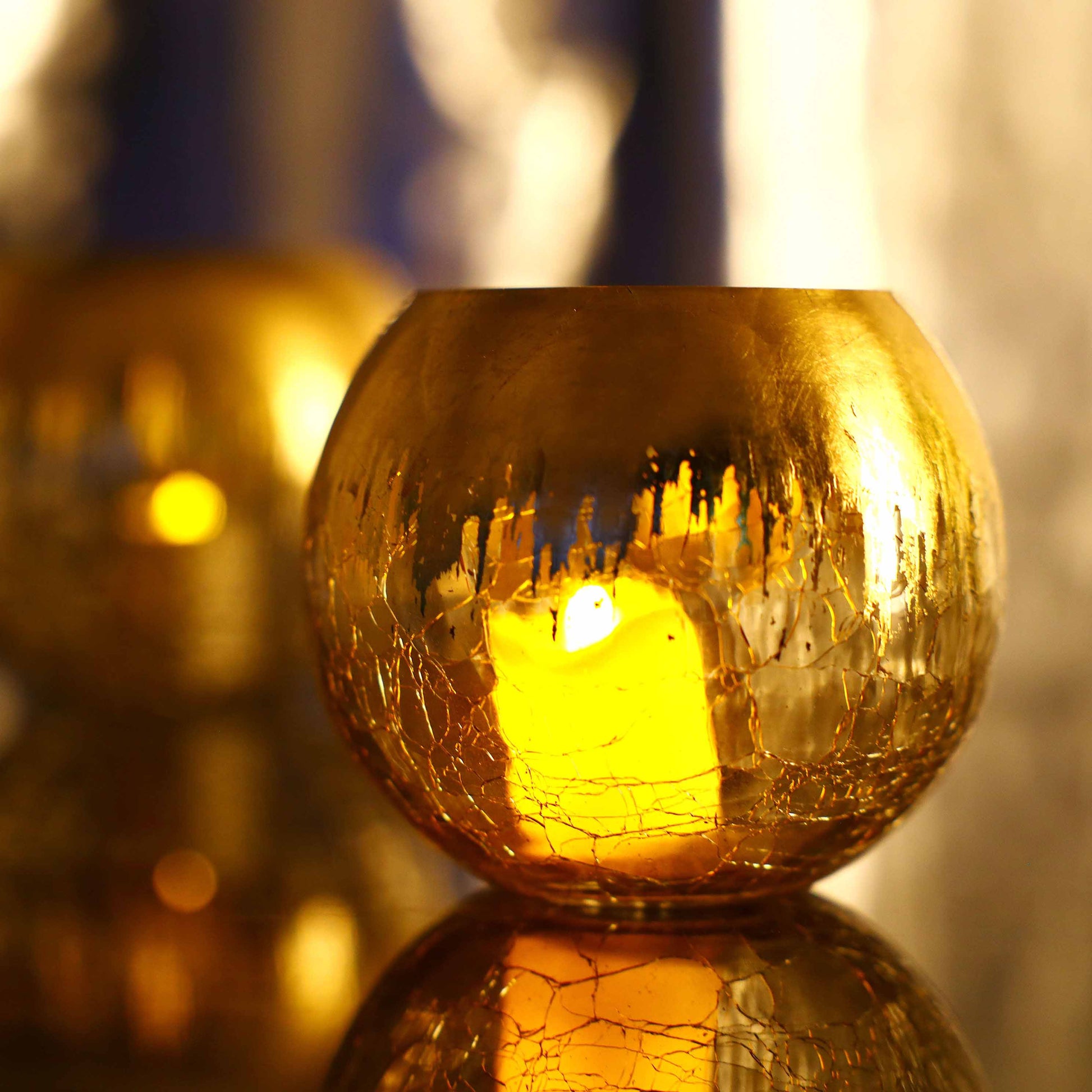 Gold foiled crackle glass bud vase centerpiece with warm glow.