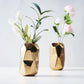 Gold metallic geometric ceramic vases with flowers.