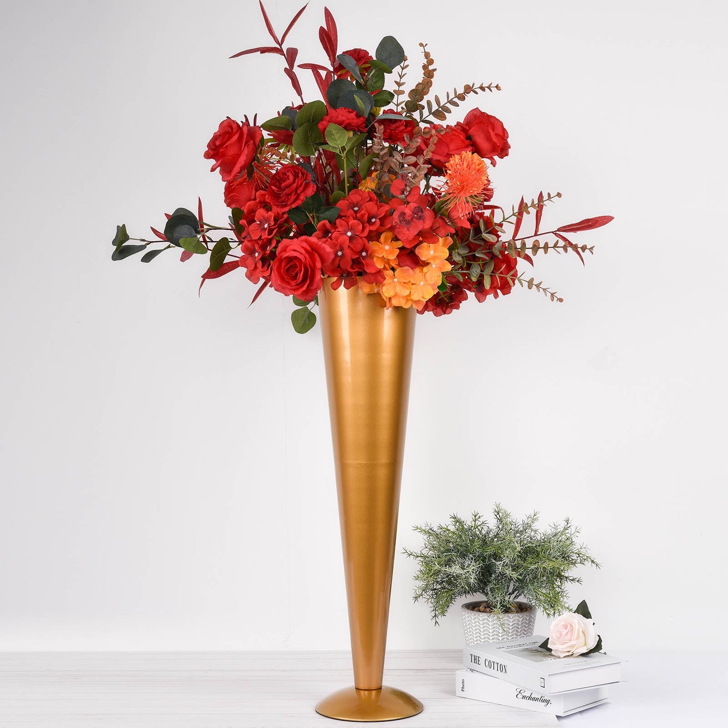 Brushed gold metal trumpet flower vase with vibrant floral arrangement.