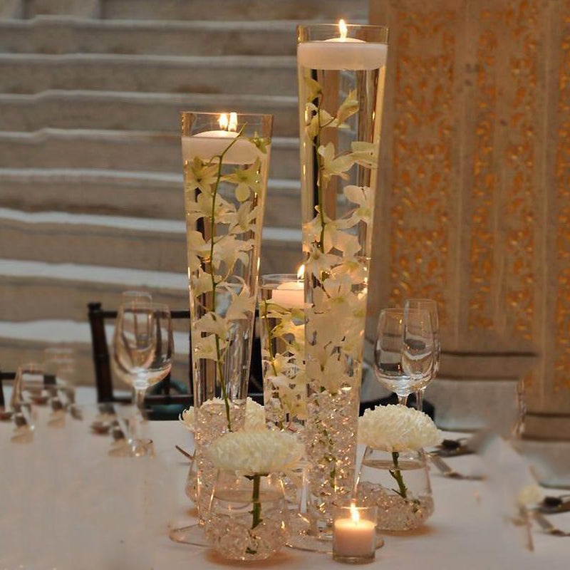 Clear heavy duty trumpet glass vases with floating candles and white flowers.