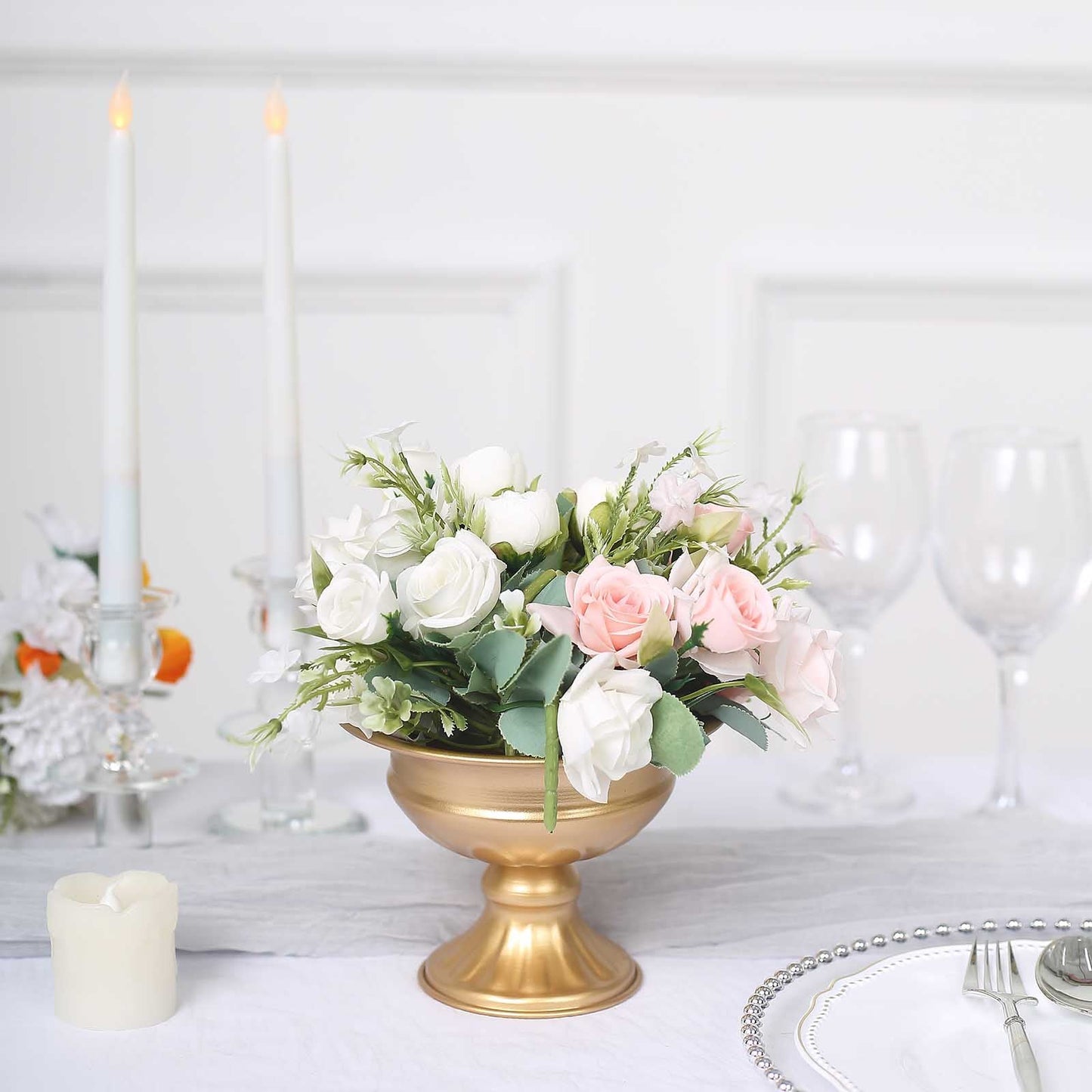 Gold metal flower vase with roses and greenery centerpiece.