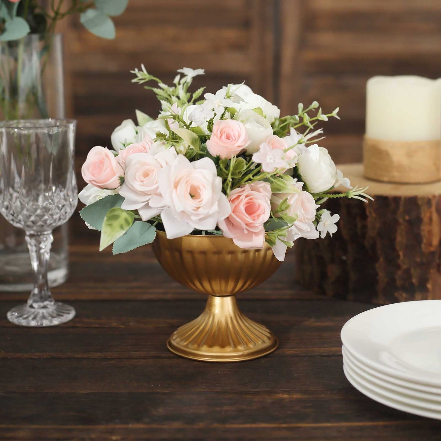 Gold ribbed pedestal vase with flowers.