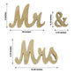 Gold glittered "Mr & Mrs" wooden photo props for rustic wedding decor.