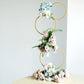 Gold metal hoop flower stand with pastel flowers, perfect for weddings and centerpieces.