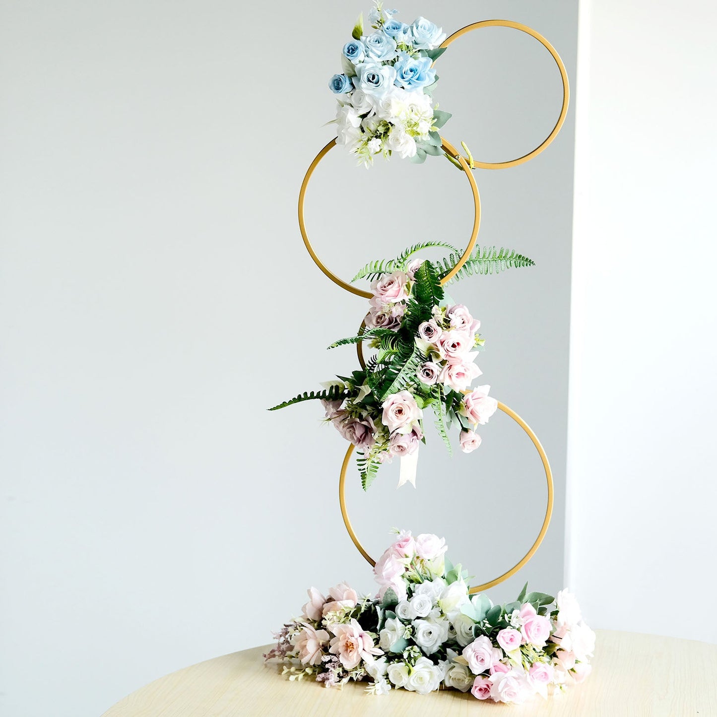 Gold metal hoop flower stand with pastel flowers, perfect for weddings and centerpieces.