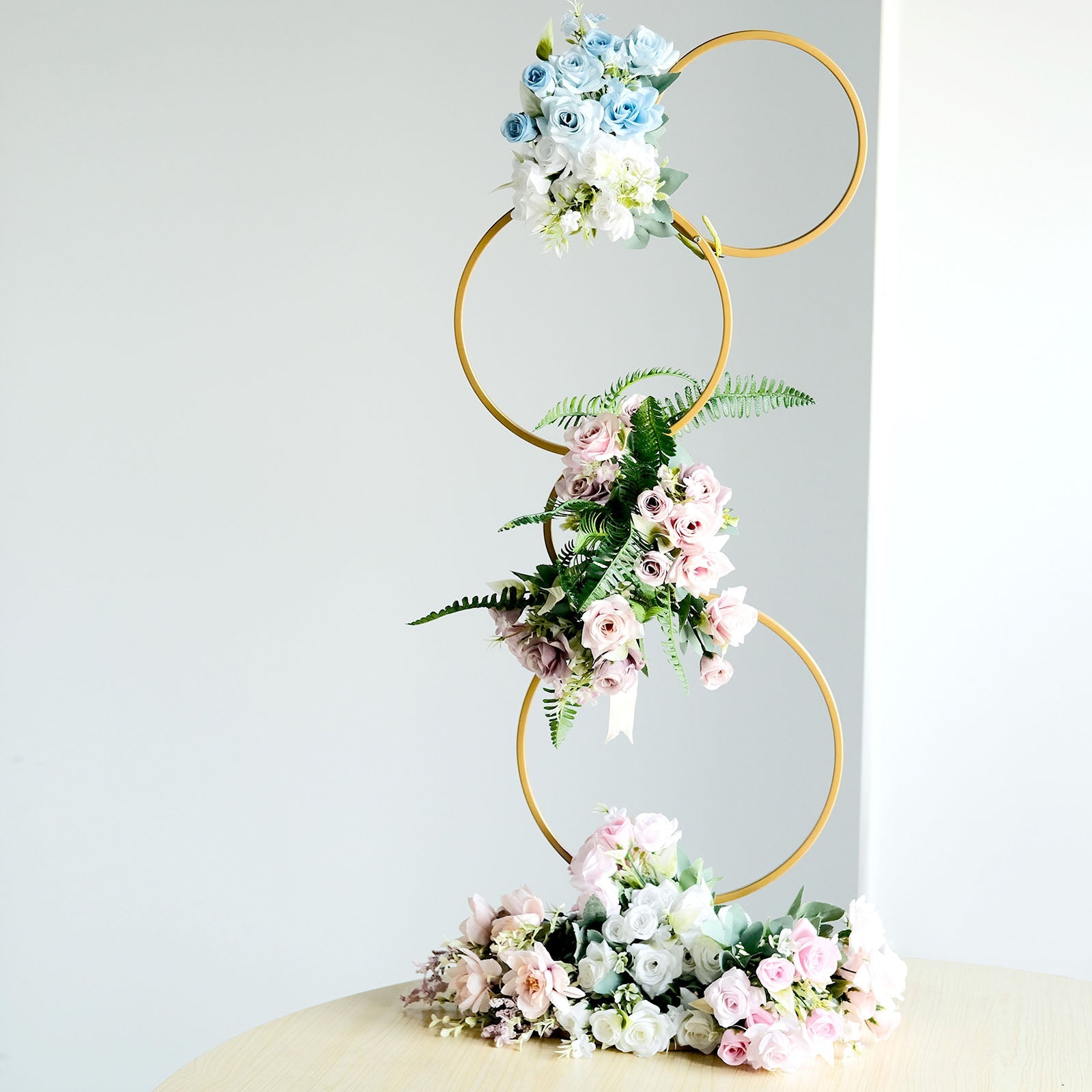 Gold metal hoop flower stand with pastel flowers, perfect for weddings and centerpieces.