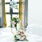 Gold metal hoop pillar flower stand with pastel floral arrangements.