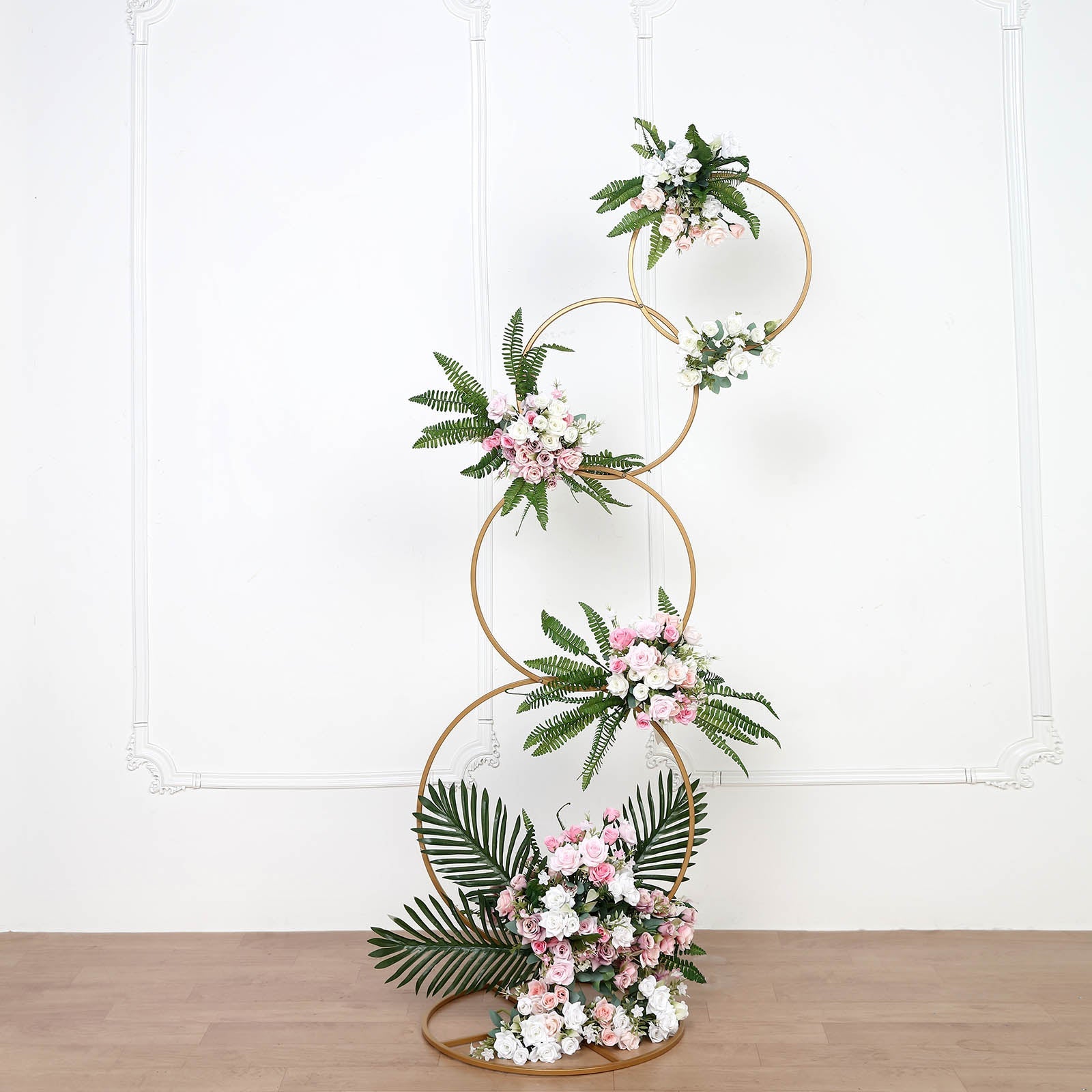 Gold hoop pillar flower stand with floral arrangements.