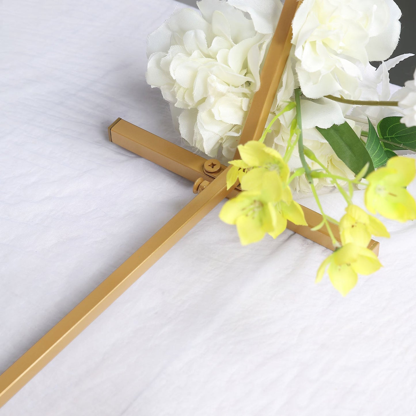 Gold hexagon table wedding arch centerpiece with flowers.