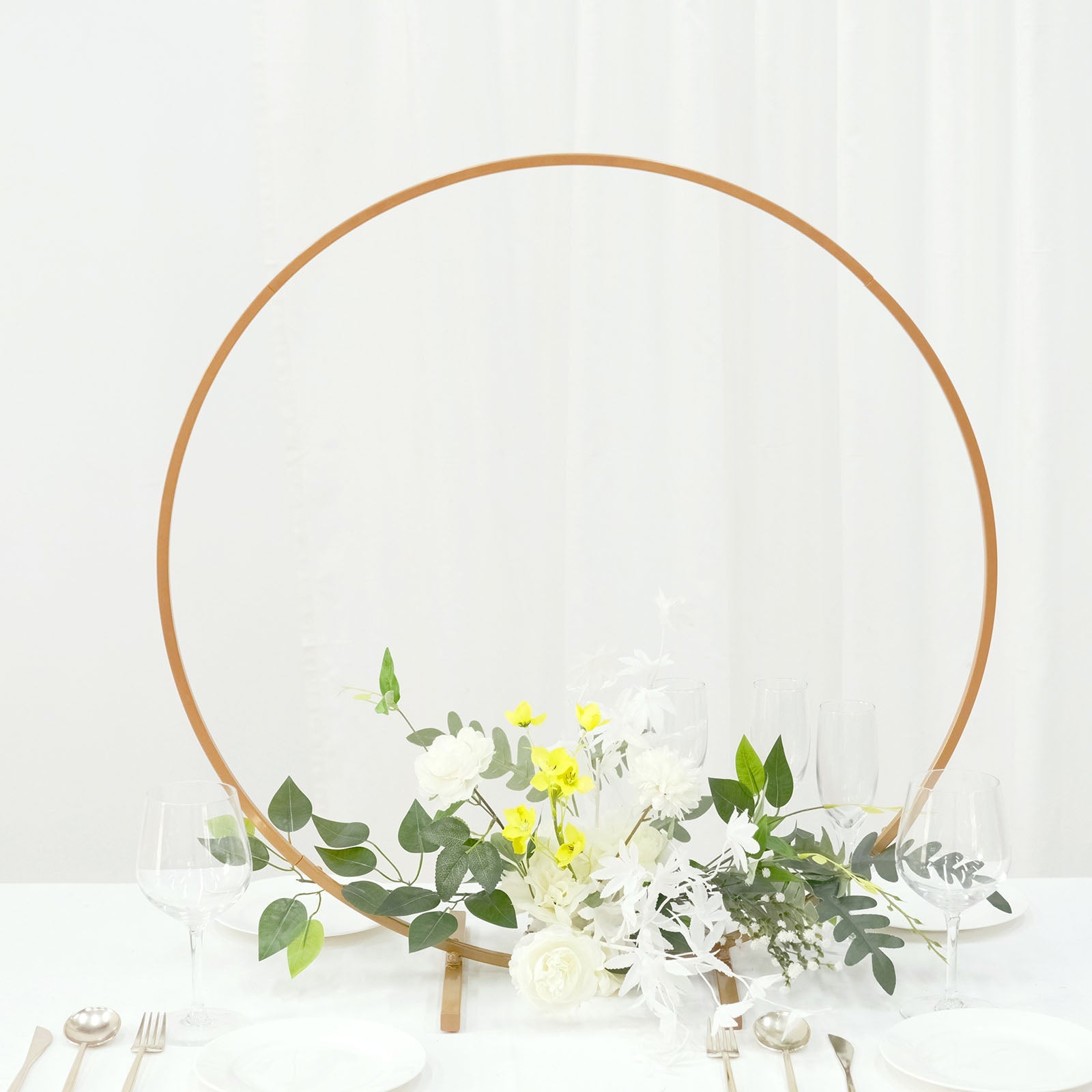 Gold metal round hoop wedding centerpiece with floral arrangement.