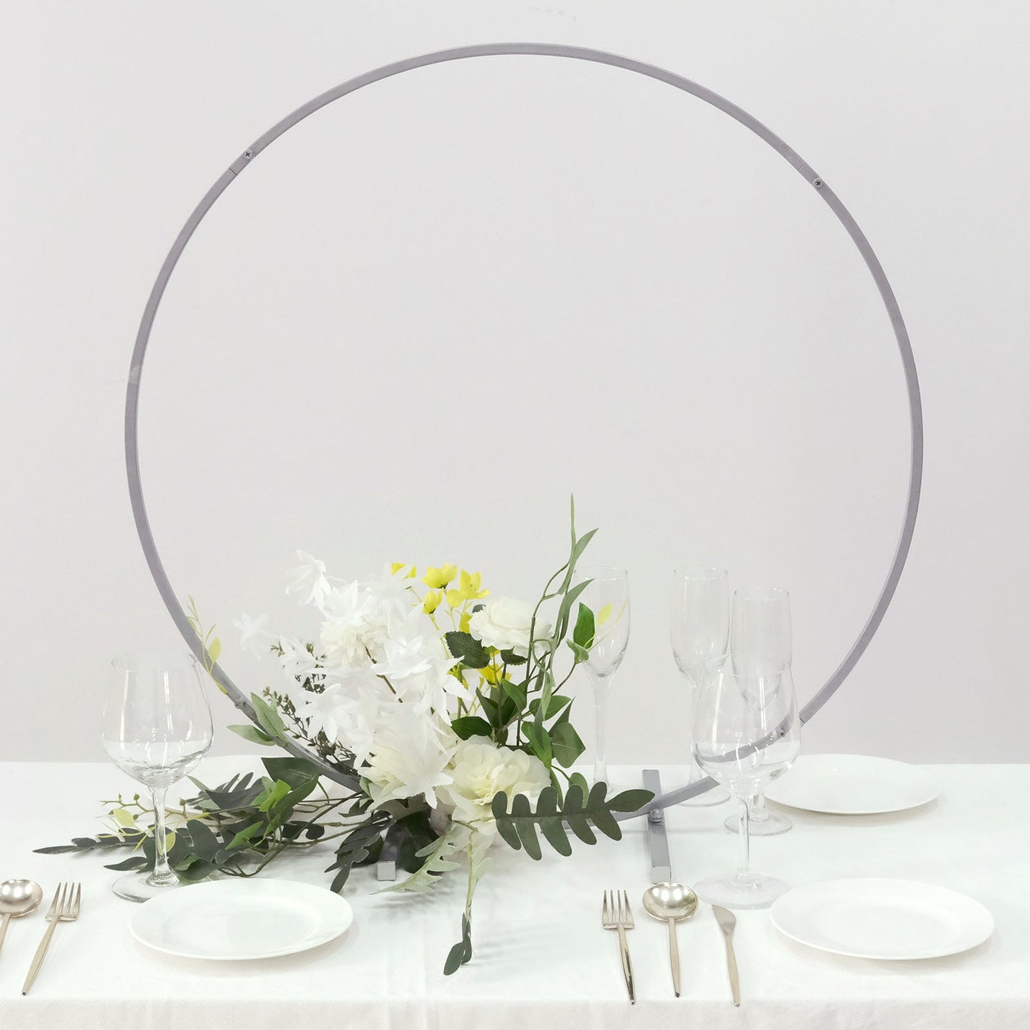 Silver metal round hoop wedding centerpiece with floral arrangement.